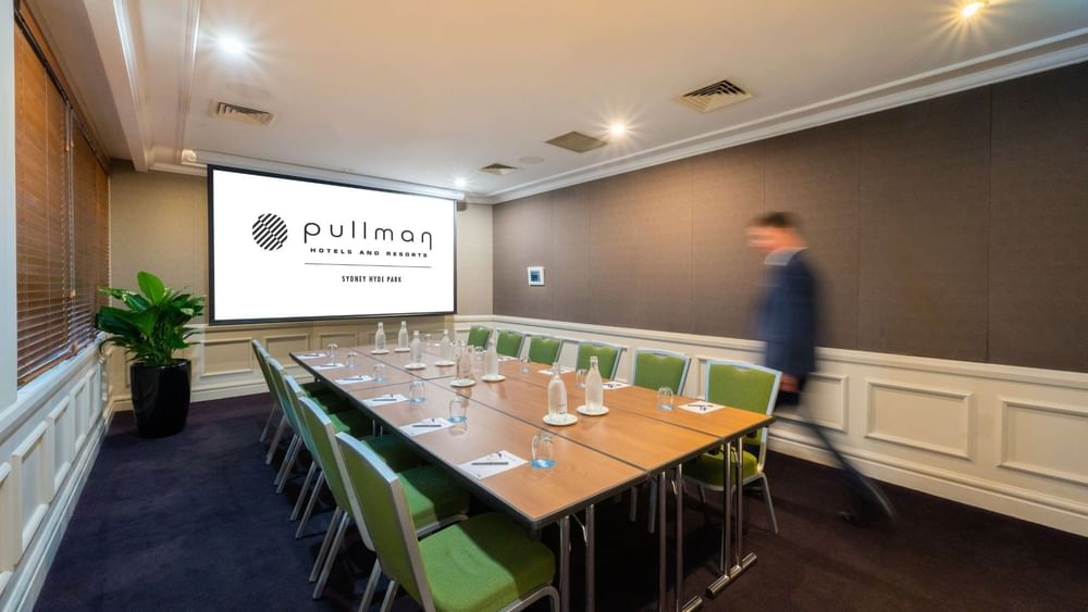 Boardroom set-up with projector screen in Dalley Room at Pullman Sydney Hyde Park