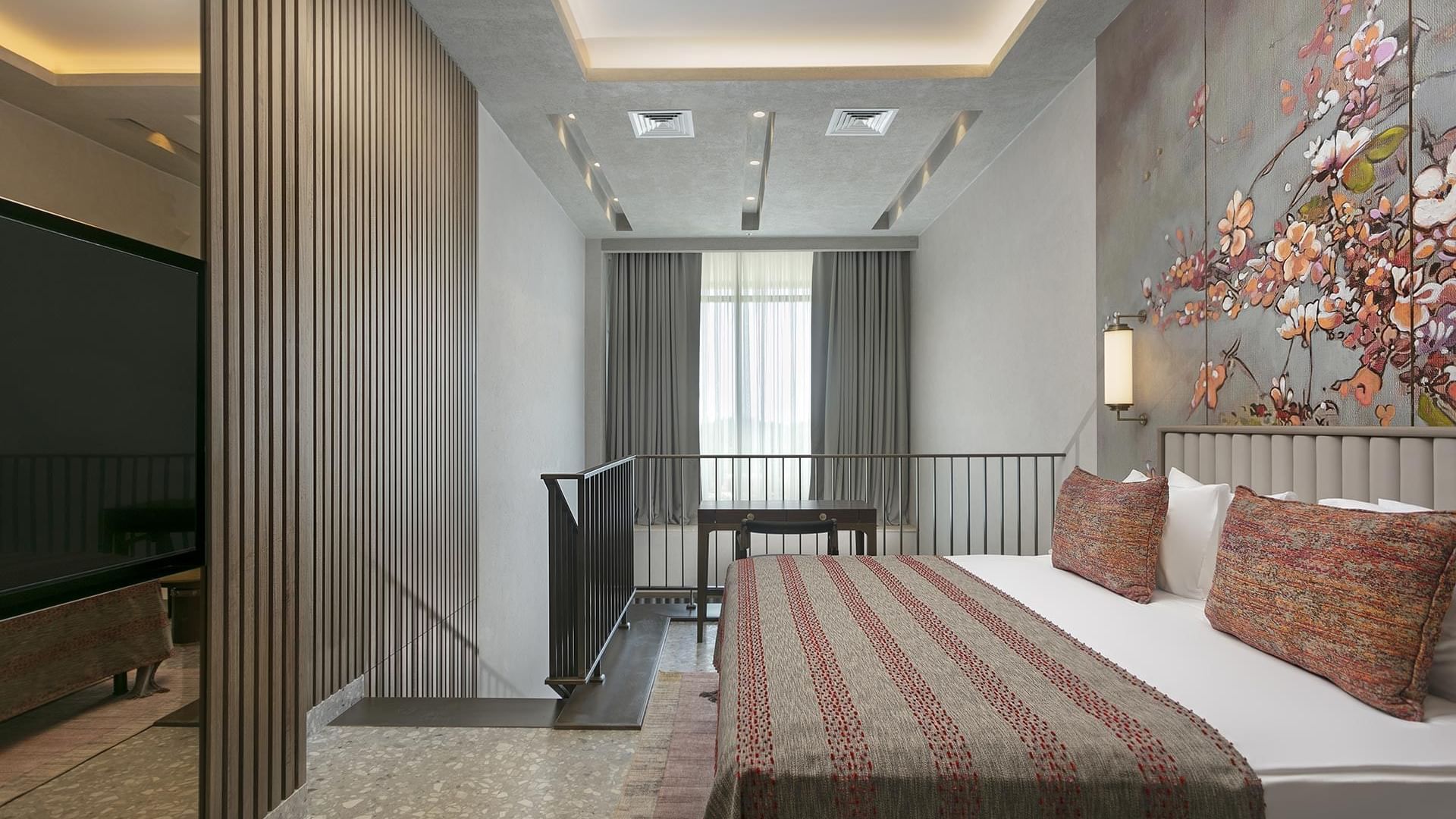 Cozy bed with floral wall art in Modern Superior Swim-up Room at Cullinan Belek