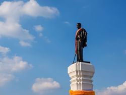 Black statue placed on a white pillar near Hop Inn Hotel