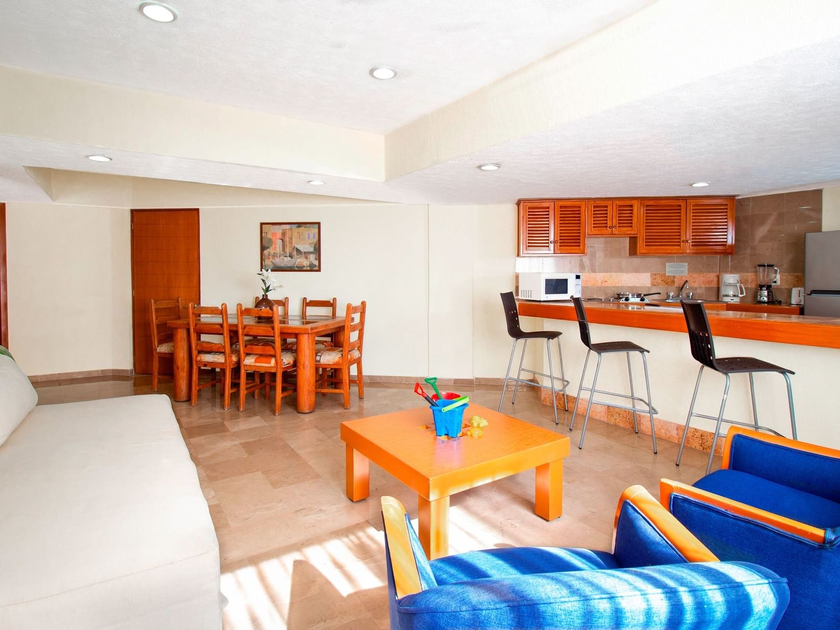 Living room with an open kitchen and dining area in 2 Bedroom Family Suite at Plaza Pelicanos Grand Beach Resort
