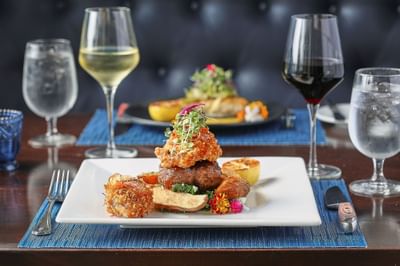 Close-up of a salmon & steak dish served with wine at Trianon Bonita Bay