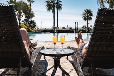 Couple enjoying drinks by the pool at Hotel Coral y Marina