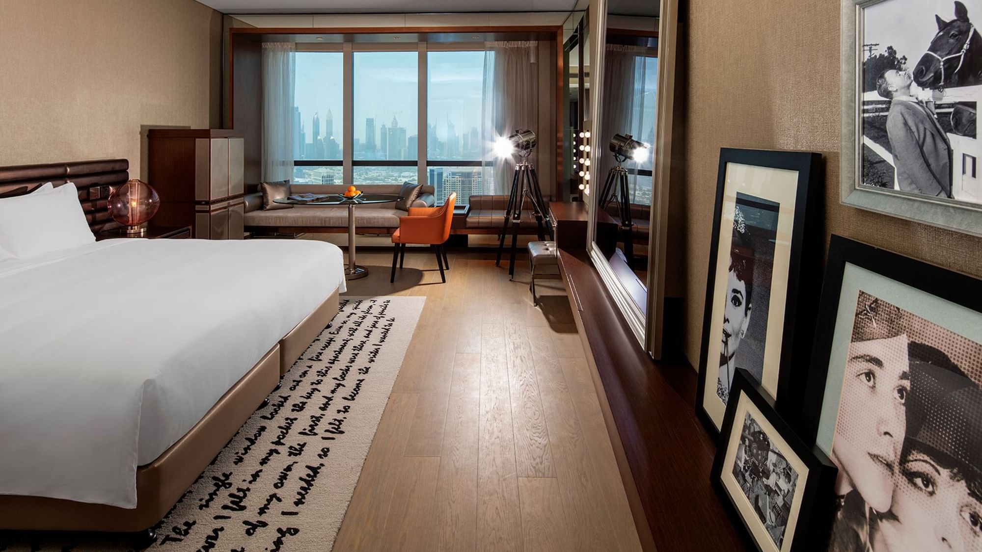 Vanity desk facing bed with seating area by the window in Scene Proscenium Room at Paramount Hotel Dubai