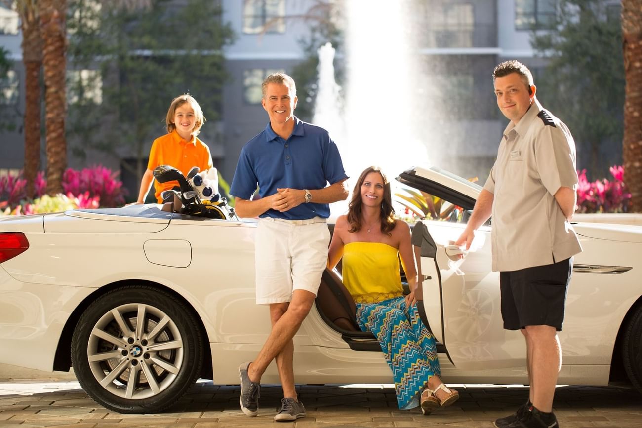 Family in a convertible car and valet opens the car door at The Grove Resort & Water Park