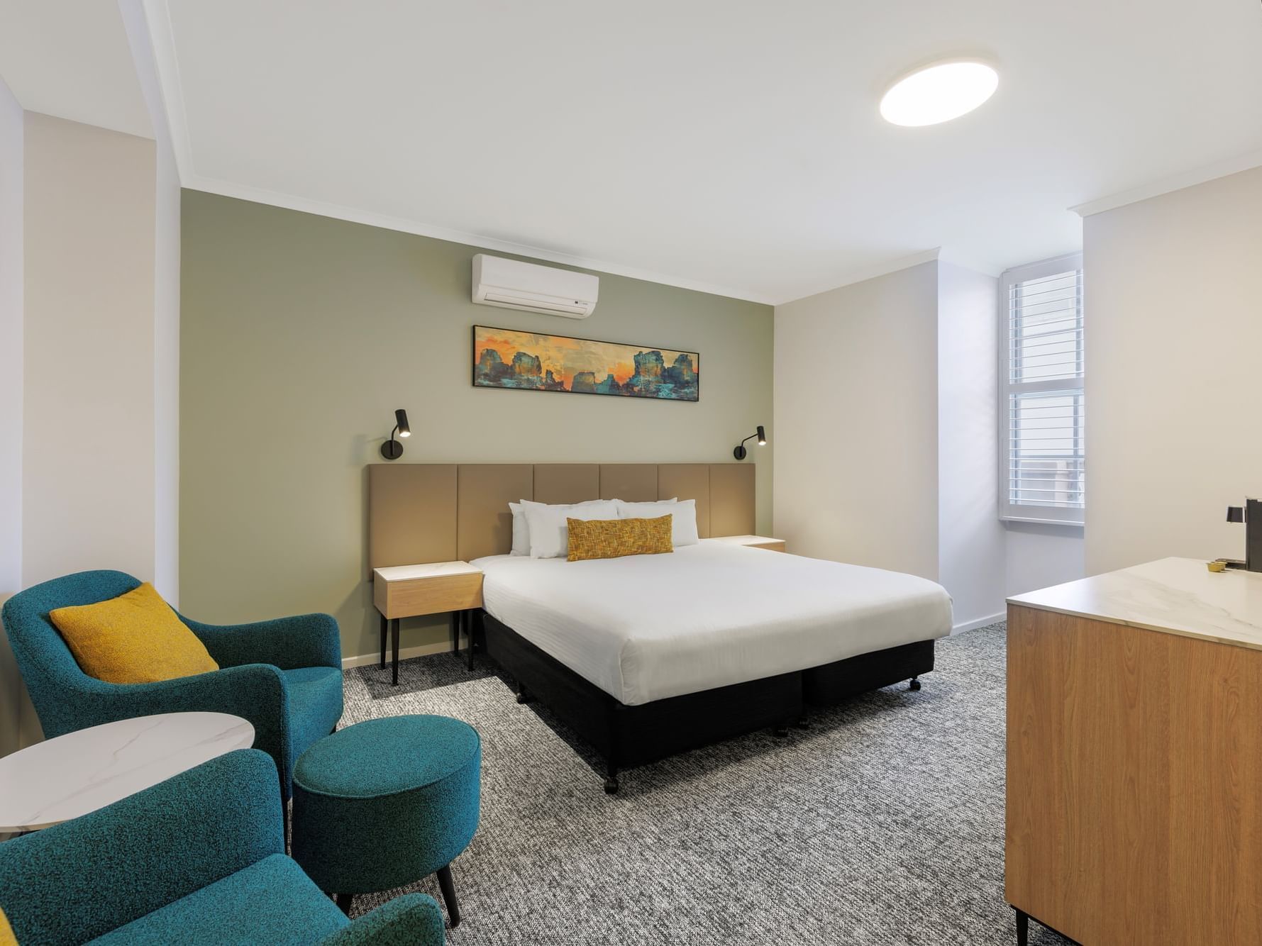 King bed, window, and TV in a well-lit hotel room.