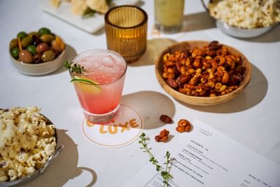 A table with popcorn, drinks & snacks in Bar Luxe, restaurants on Sunset Blvd at Luxe Sunset Boulevard Hotel