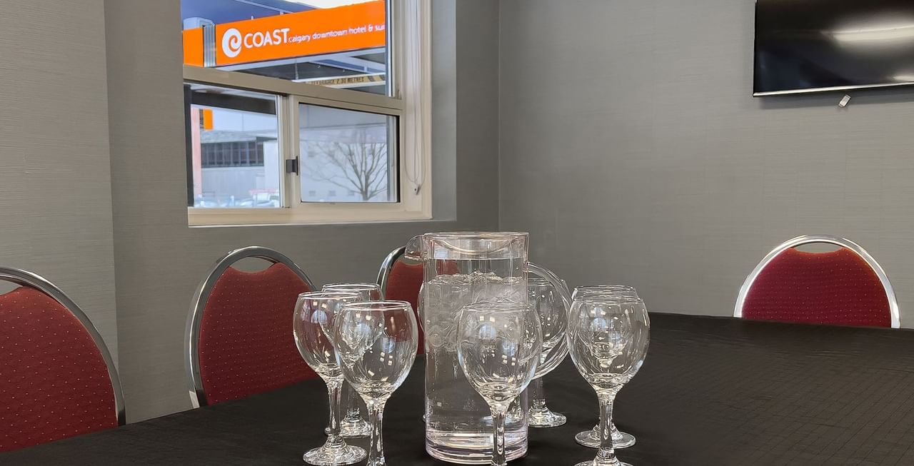 Coast Calgary Downtown Hotel & Suites by APA meeting room with chair, table, and TV