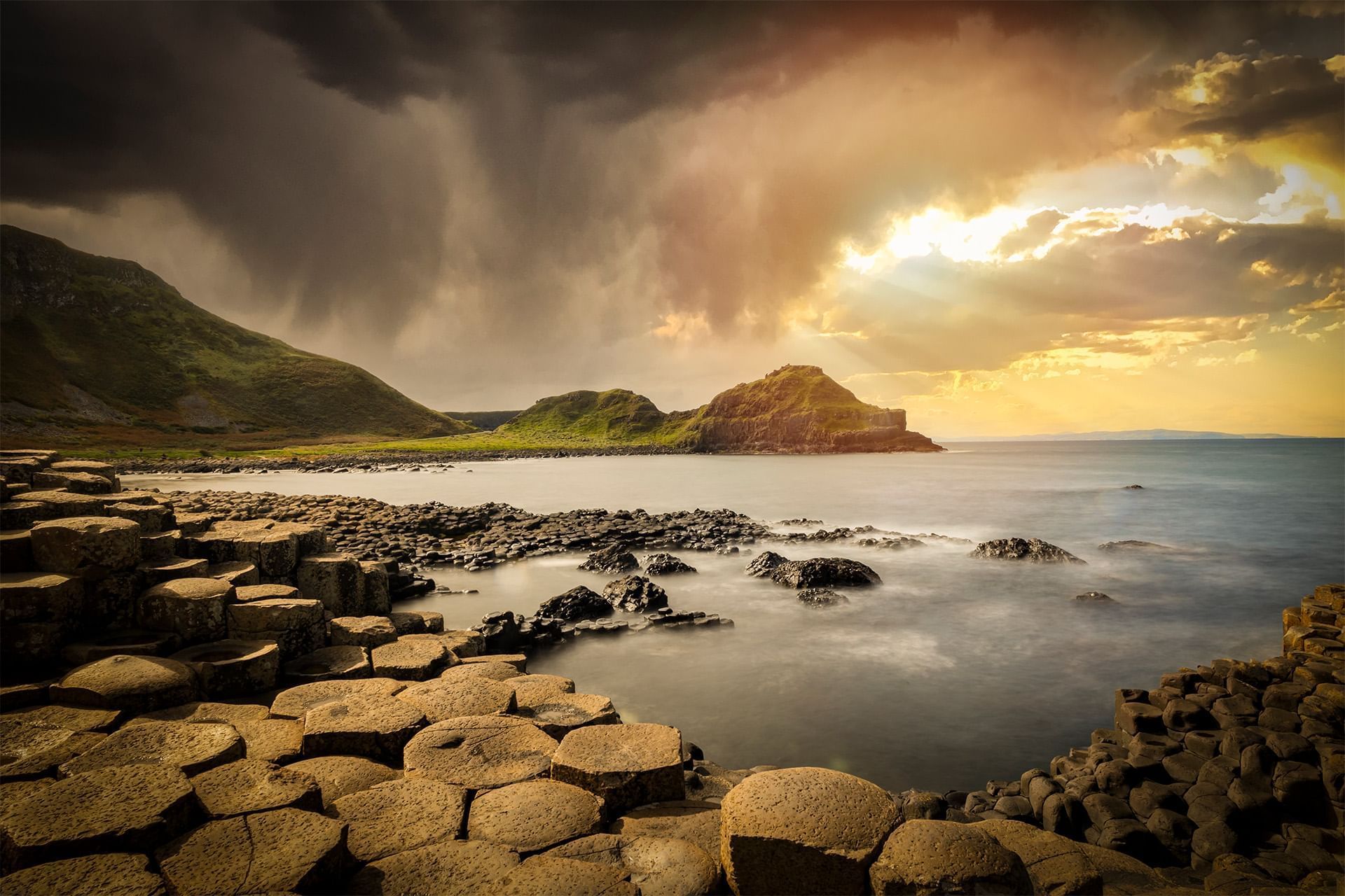 Striking image of the Giant's Causeway with dramatic sky and storm clouds near Dunluce Lodge
