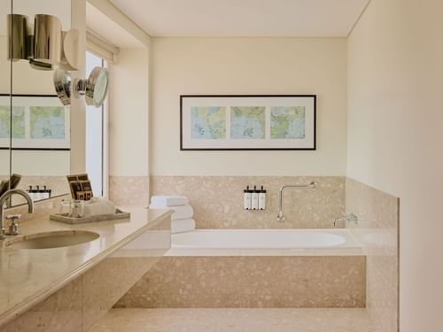 Bathroom with a marble counter, bathtub, and art on the wall in Signature Suite at Sofitel Brisbane Central