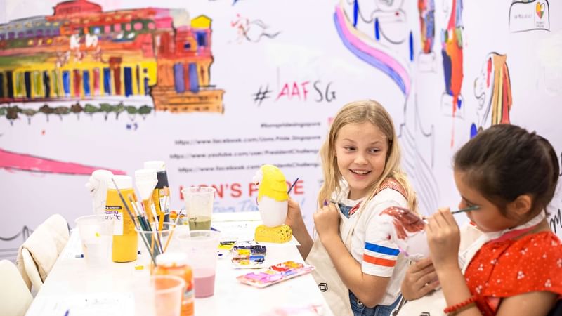 Two girls painting mini statues at Fullerton Group