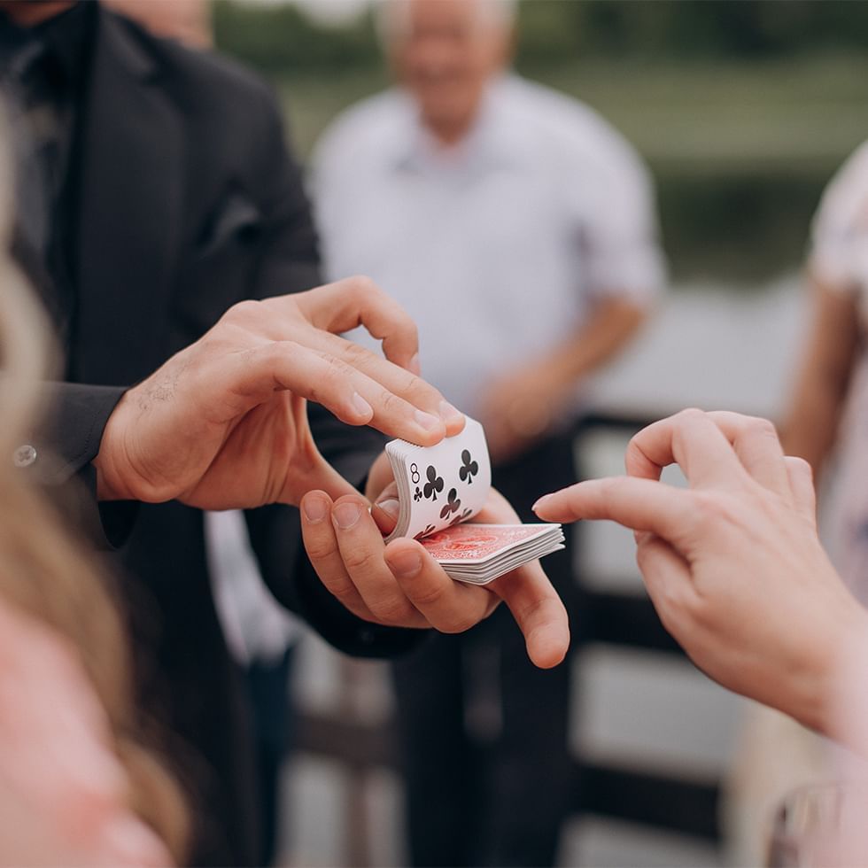 Magician performing Moments of Magic & Rhythm with a deck of cards for an audience.