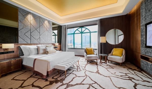 King bed, chairs & a mirror in Premier Suite at Sunway Resort
