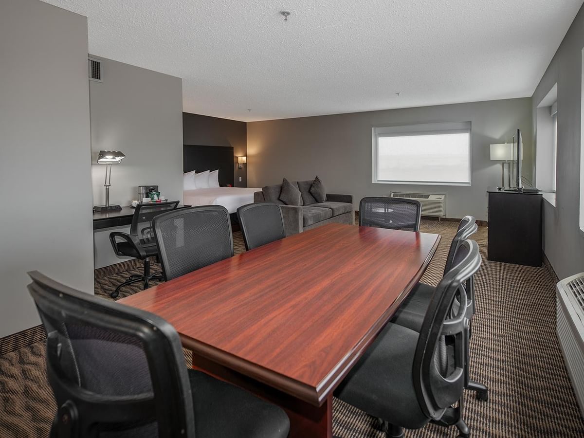 Spacious hotel suite with table and chairs.