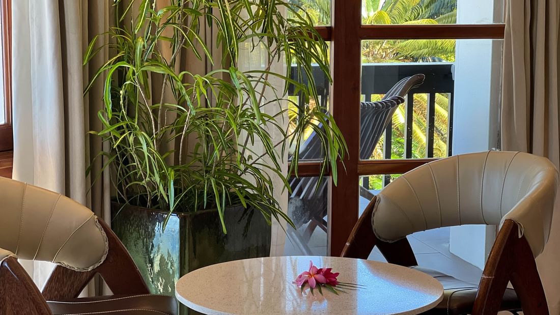 Chairs around a table with a flower and a potted plant at Warwick Fiji Resort and Spa, Korolevu.