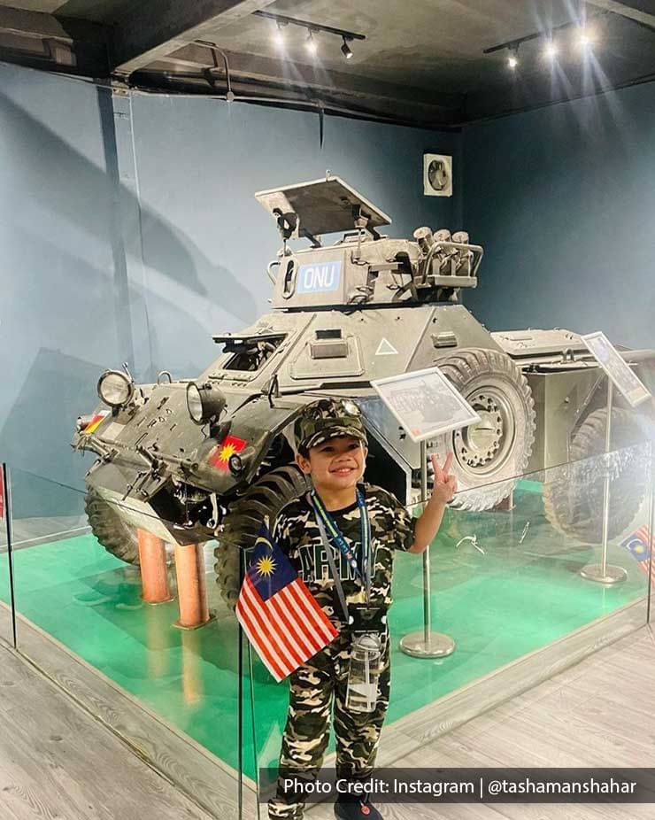 Indoor museum display of tank with a kid wearing army uniform - Lexis Port Dickson