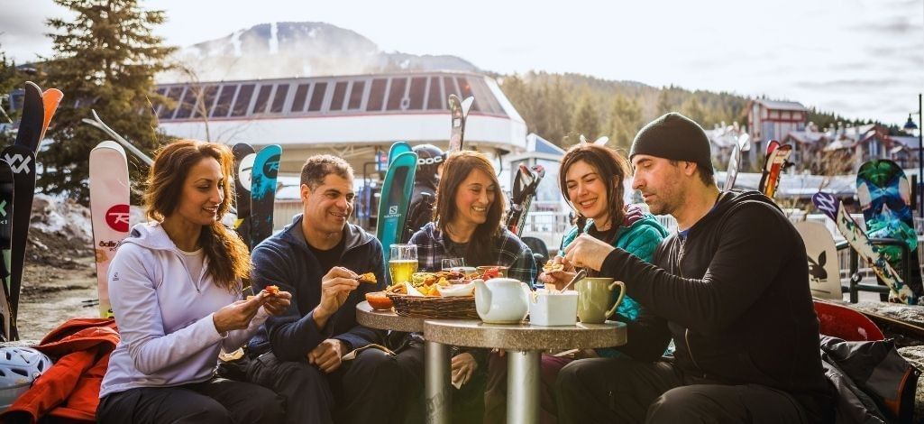 Group sharing a meal after skiing at Whistler village base