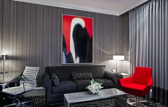 a black couch and red chair in a hotel room