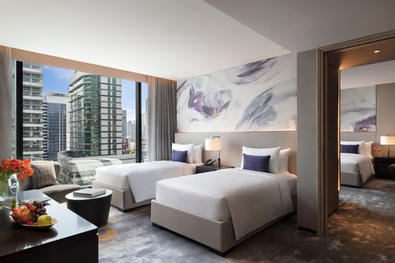 Beds in family room with city view at Carlton Hotel Bangkok Sukhumvit