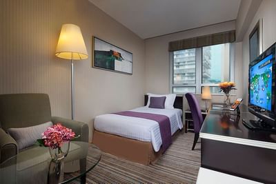 Bed by the window with a city view in Superior Single Room at Park Hotel Hong Kong