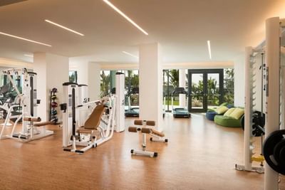 Gym with various workout machines, treadmills, and colorful bean bags by large windows at The Residences at Seafire