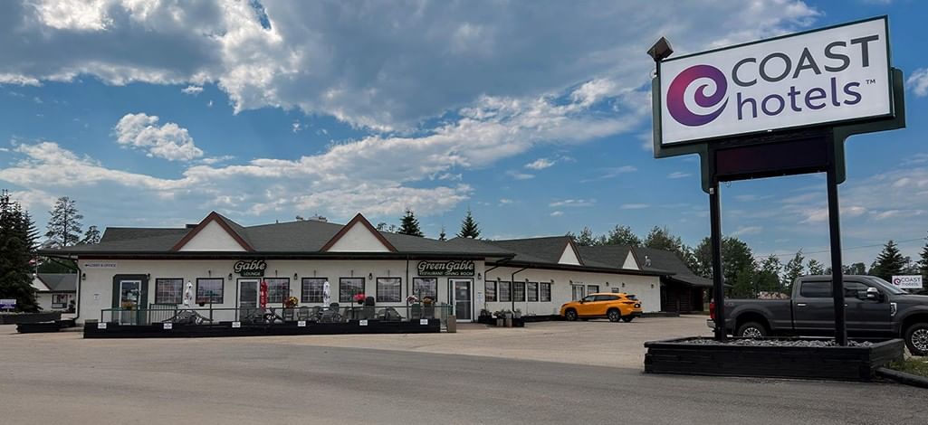 Coast Whitecourt Hotel exterior with blue sky and clouds in the background
