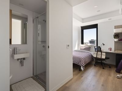 Modern bedroom with desk and bathroom at UniLodge Perth Central.
