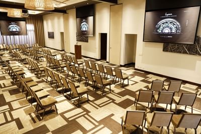 Theatre-style set up with projector screens in a modern conference room at El Mangroove Hotel