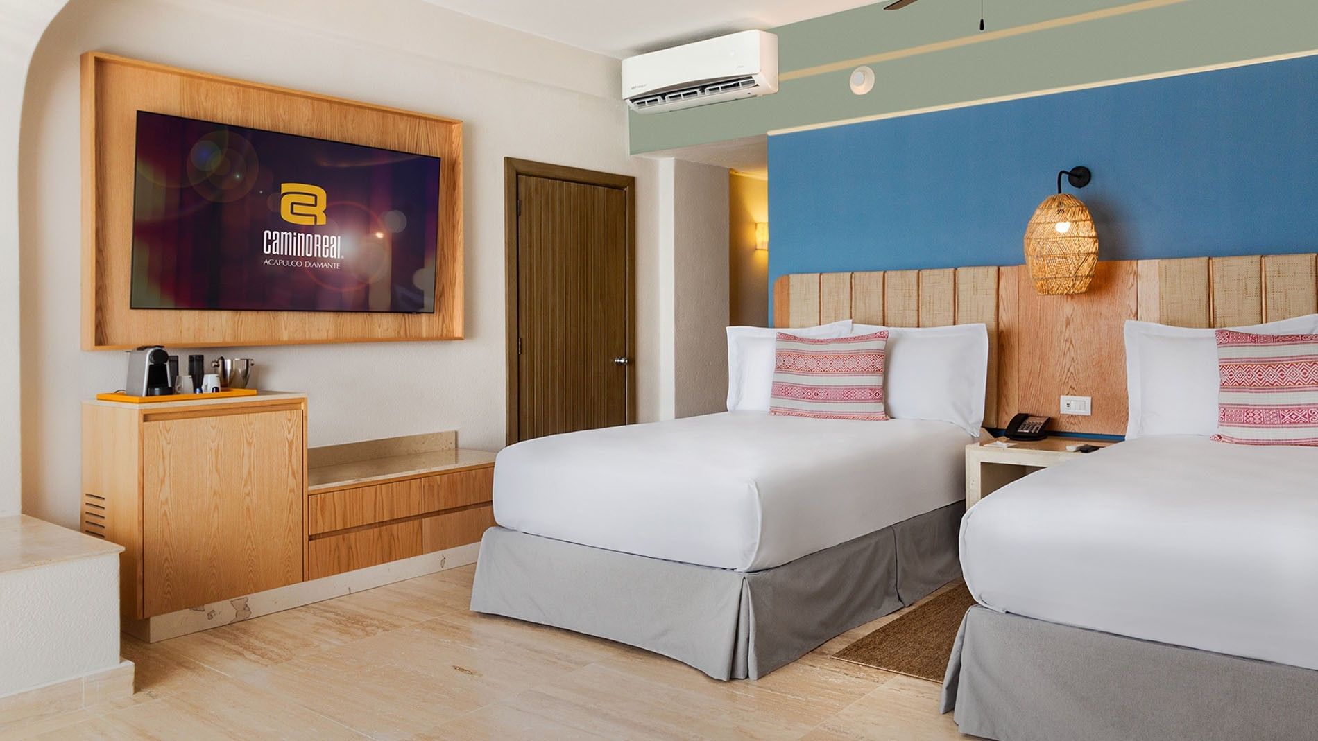 Wall-mounted TV and wooden accents by the bed in Two Double Camino Real Club at Camino Real Acapulco Diamante
