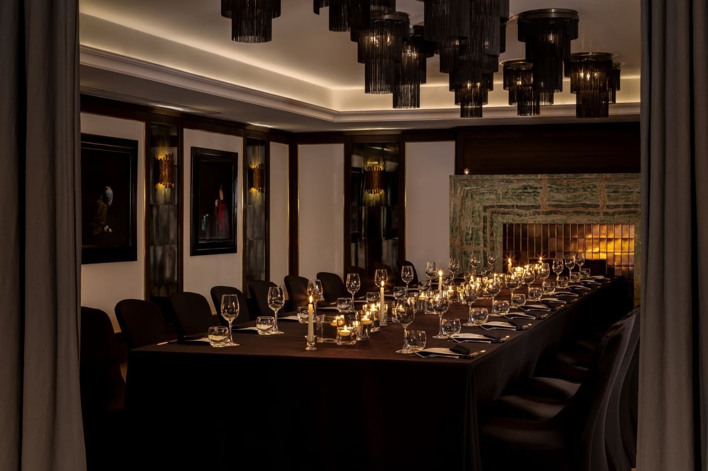 Elegantly set dining table with candles and wine glasses in a sophisticated room at The May Fair Hotel, London.