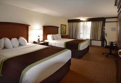 Two beds with nightstand in a room at Rosen Inn Lake Buena Vista