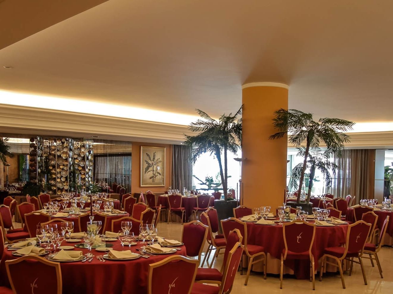 Room with round tables and red chairs at Hotel Cascais Miragem