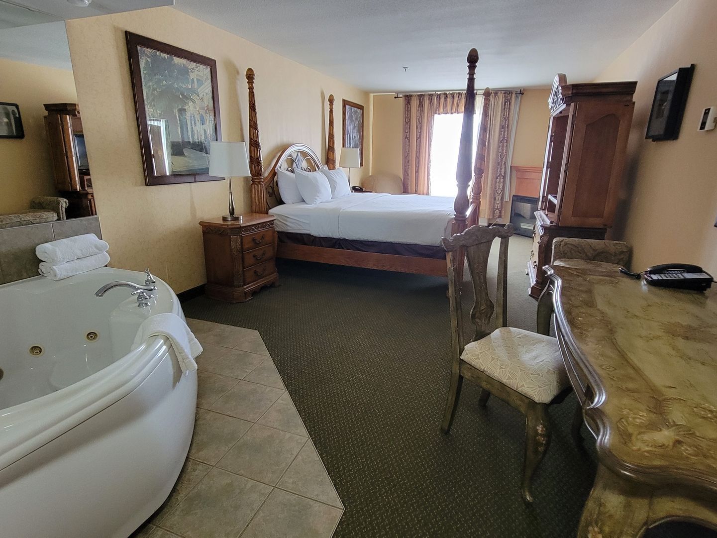 Workspace & jetted tub by bed in Arabian Suite at Merit Hotel & Suites, Fort McMurray hotels