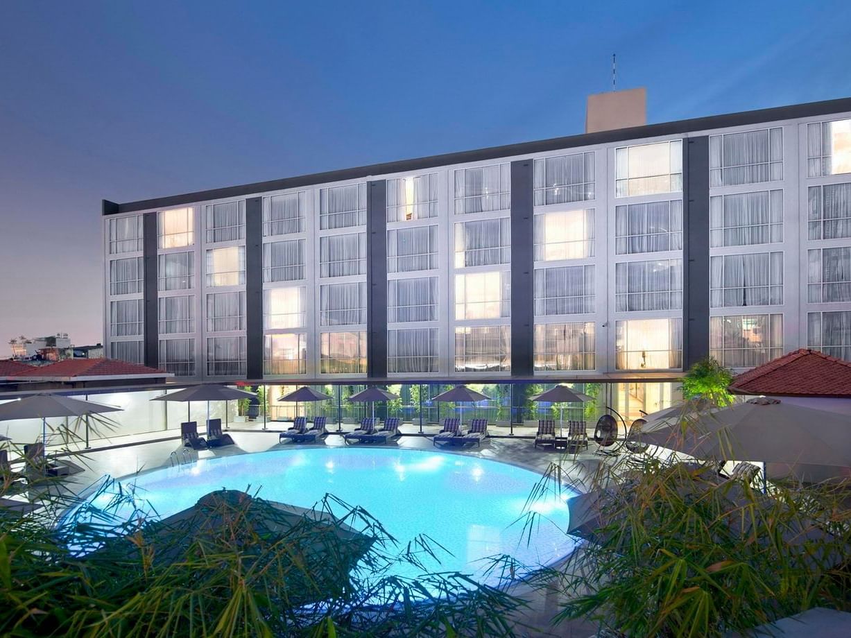 Round shaped outdoor pool with lounge beds at Eastin Hotels