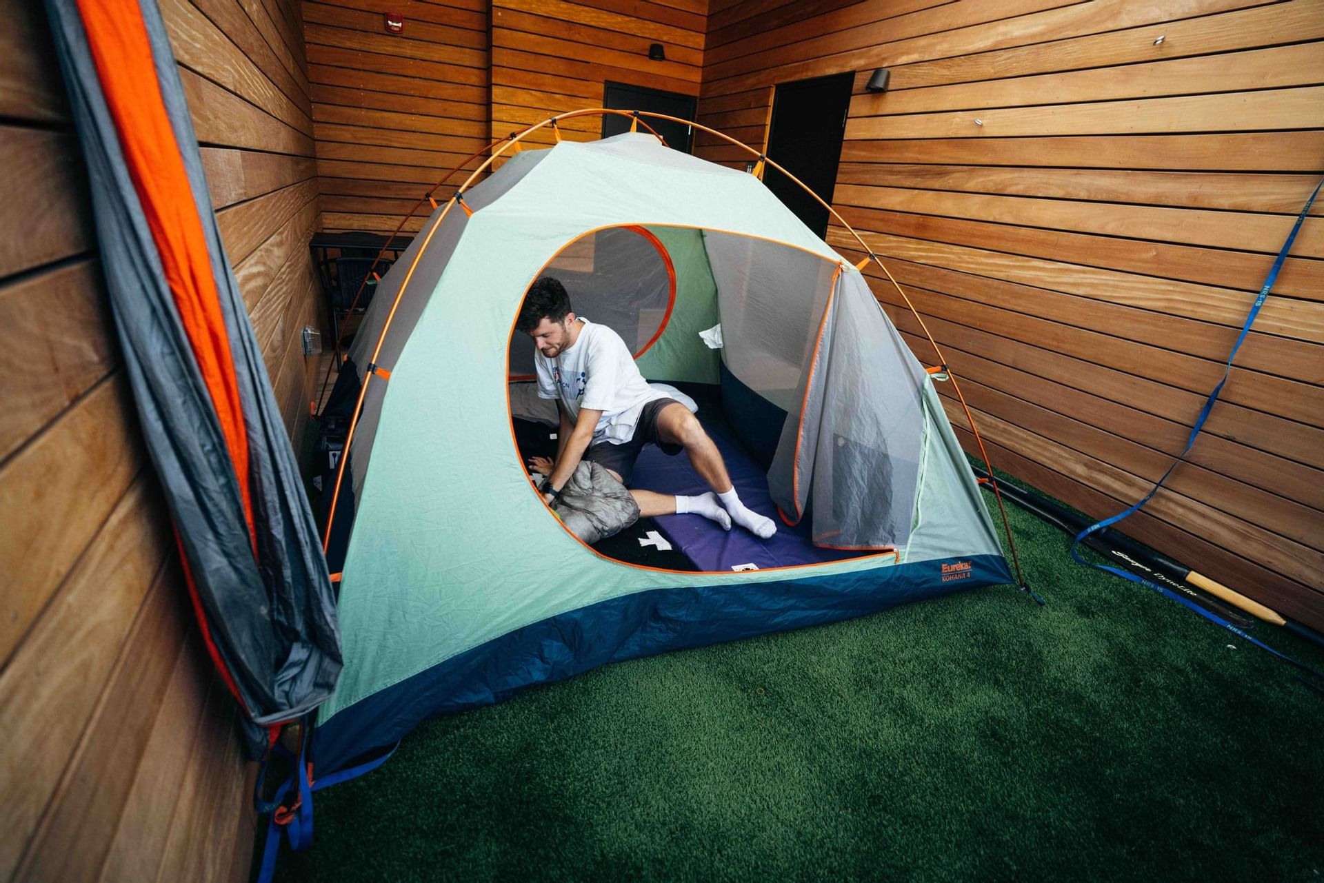 Man setting up a tent in the Camp Deck at Kinship Landing