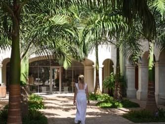 Lady walking through a palm-lined courtyard at Limegrove Lifestyle Centre near All Seasons Resort Europa