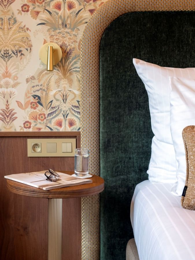 Superior Room with dark green velvet headboard and floral wallpaper at Warwick Brussels Grand-Place in Brussels