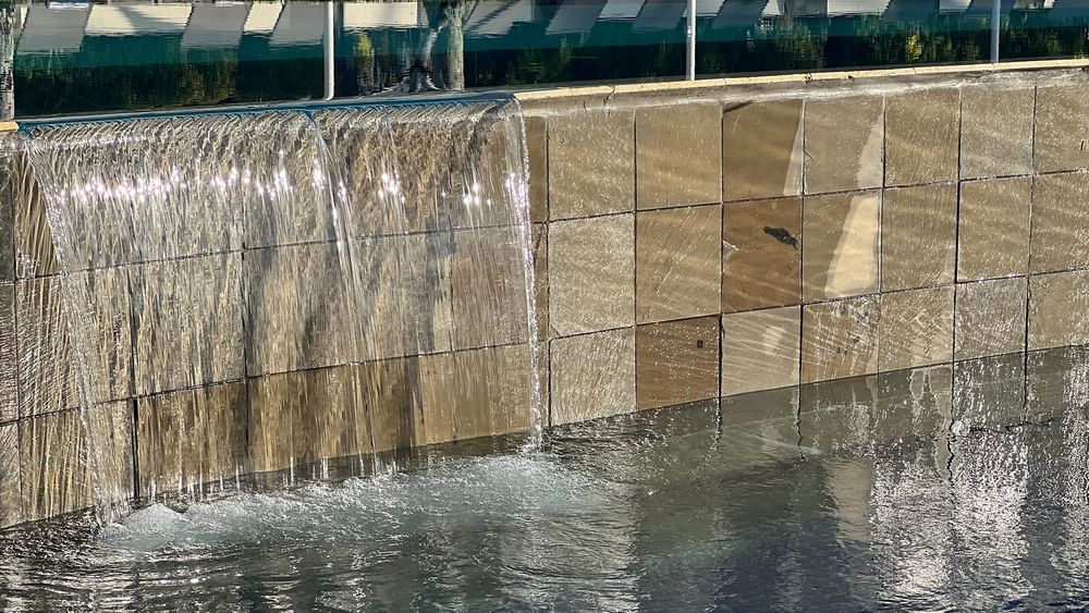 Water flowing into a pool with lounge chairs at Warwick Le Lagon in Efate.
