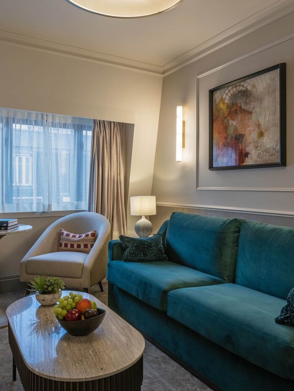 Suite with teal couch, chair, and coffee table at The Capital Hotel, Apartments & Townhouse