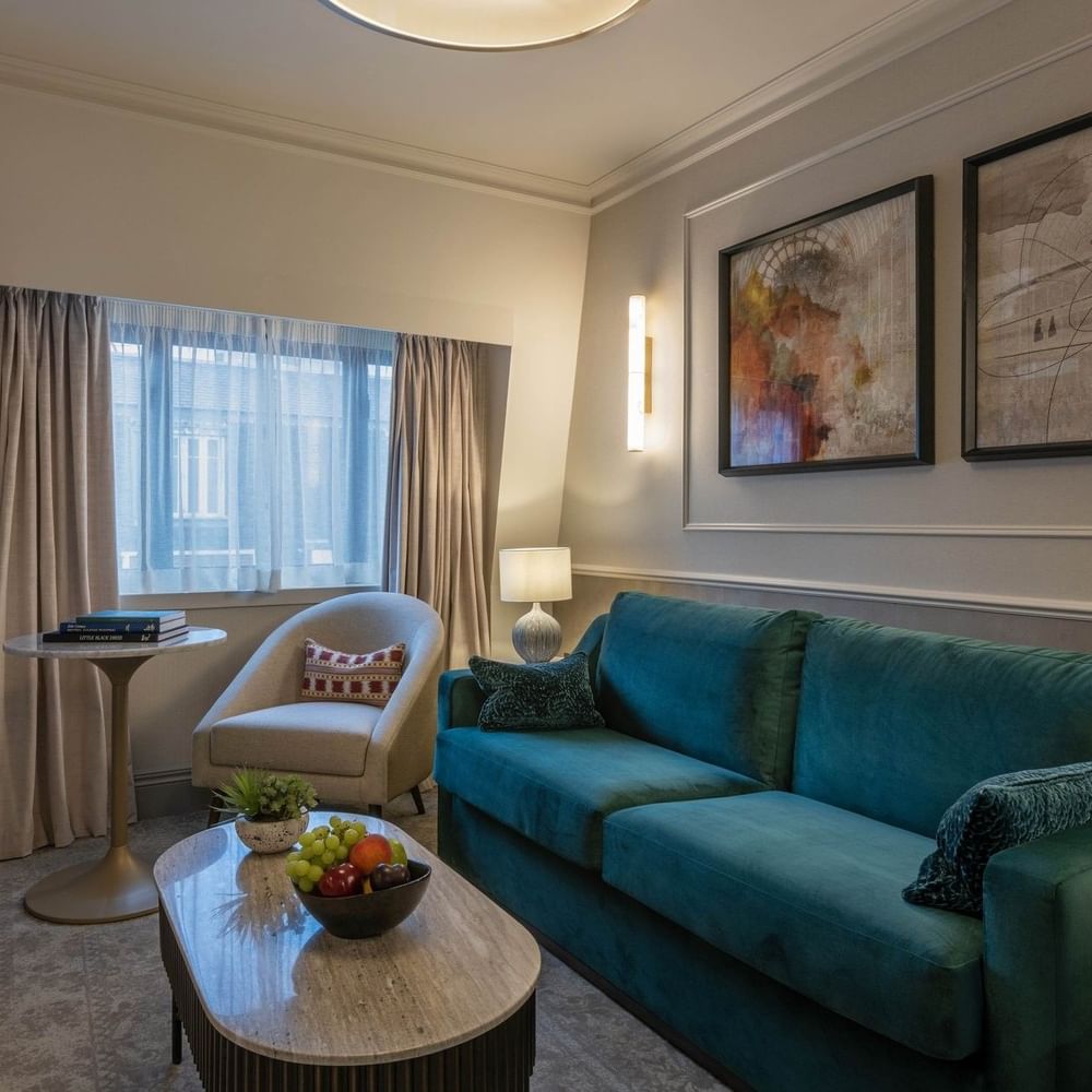 Junior Suite living area with plush sofas near window at The Capital Hotel, Apartments and Townhouse