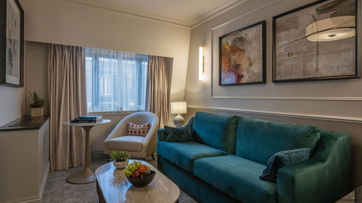 Junior Suite living area with plush sofas near window at The Capital Hotel, Apartments and Townhouse