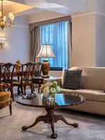 Suite of the Stars living area with sofa, dining table, and chandelier at Warwick New York
