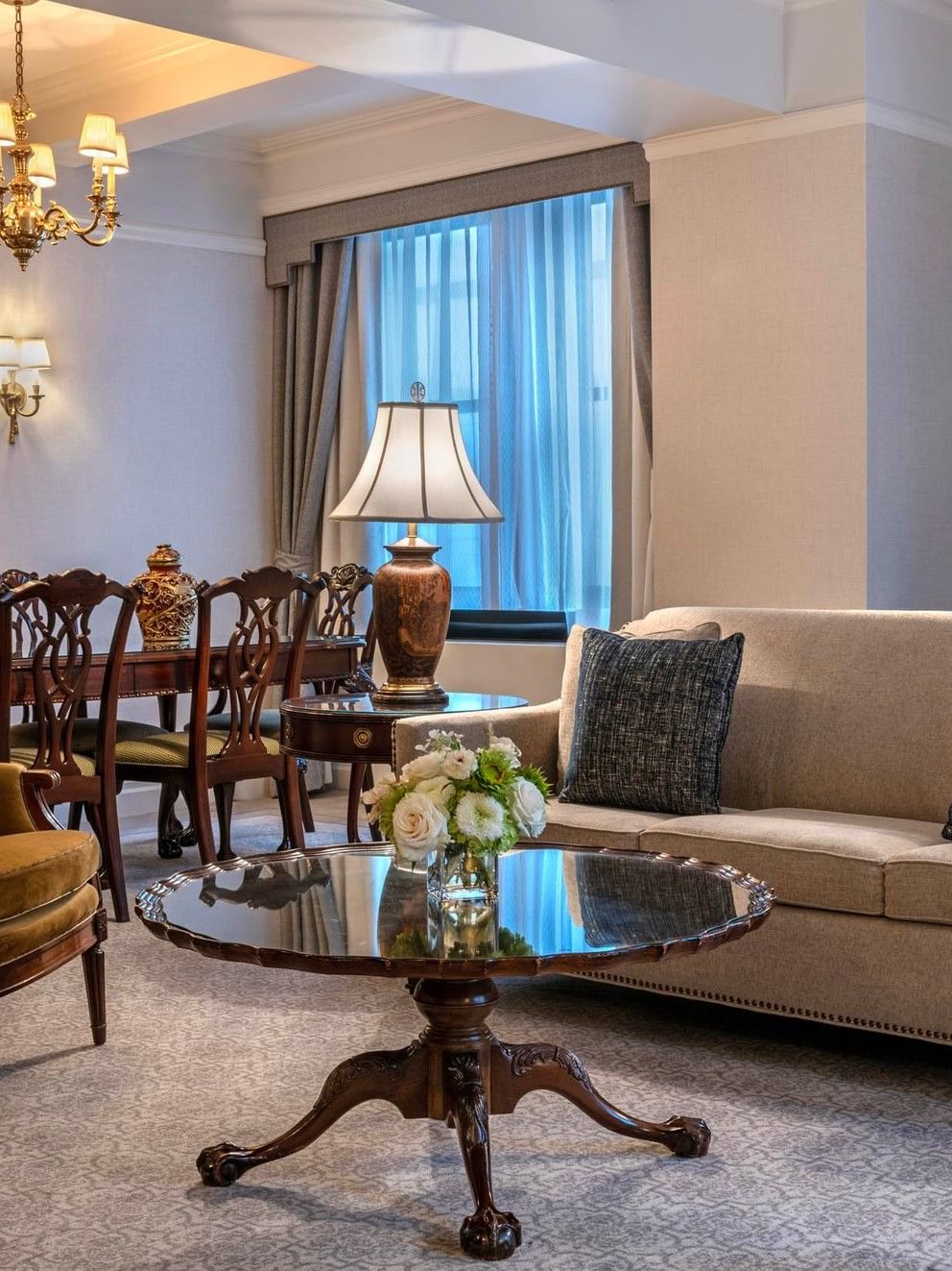 Suite of the Stars living area with sofa, dining table, and chandelier at Warwick New York