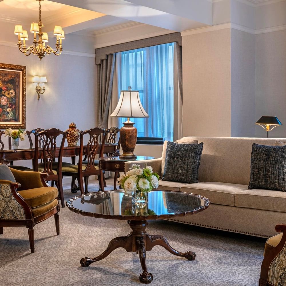 Suite of the Stars living area with sofa, dining table, and chandelier at Warwick New York