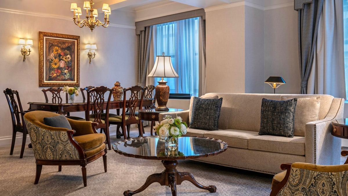 Suite of the Stars living area with sofa, dining table, and chandelier at Warwick New York