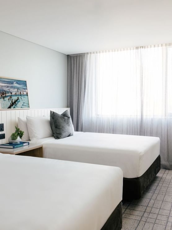 Village Twin at Elysium Manly with cushions by a wooden desk near sheer window curtains, offering cozy Manly accommodation