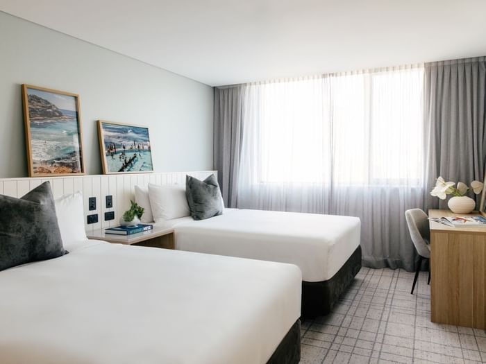 Village Twin at Elysium Manly with cushions by a wooden desk near sheer window curtains, offering cozy Manly accommodation