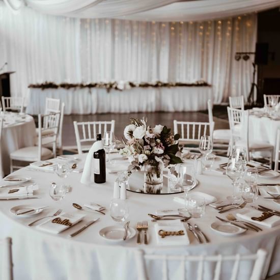 A wedding reception with white chairs and tables at Pullman Magenta Shores