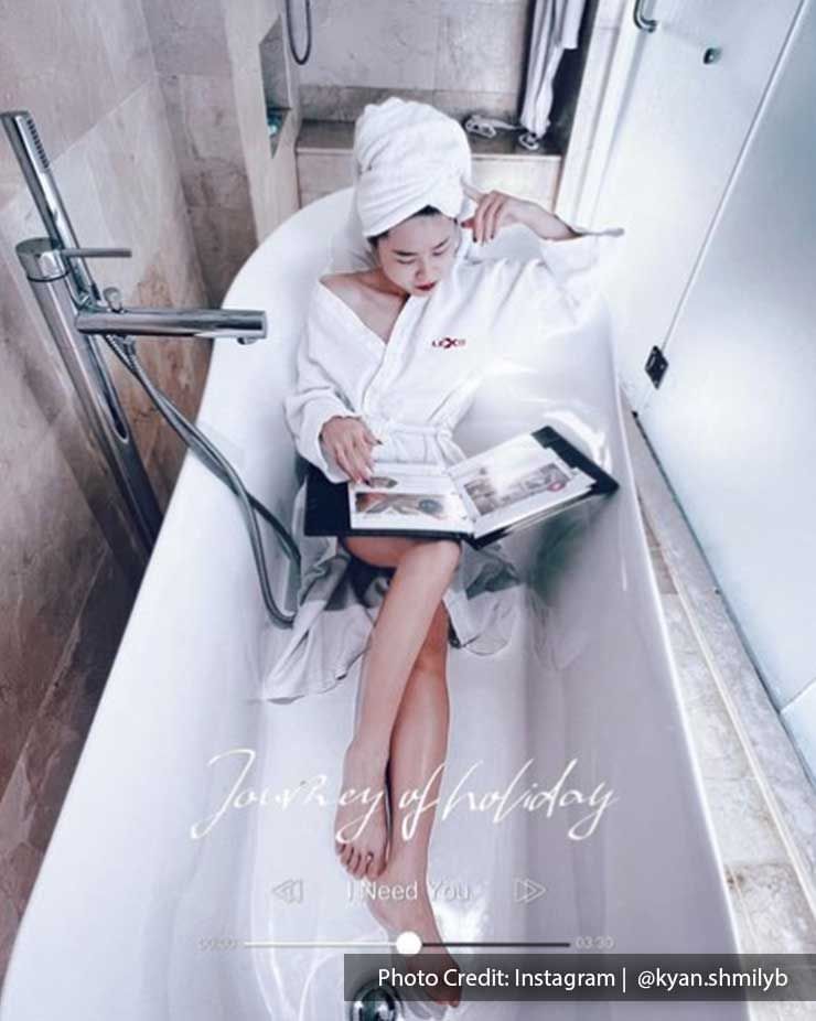 Woman working in the bathtub at Lexis Hotel MY