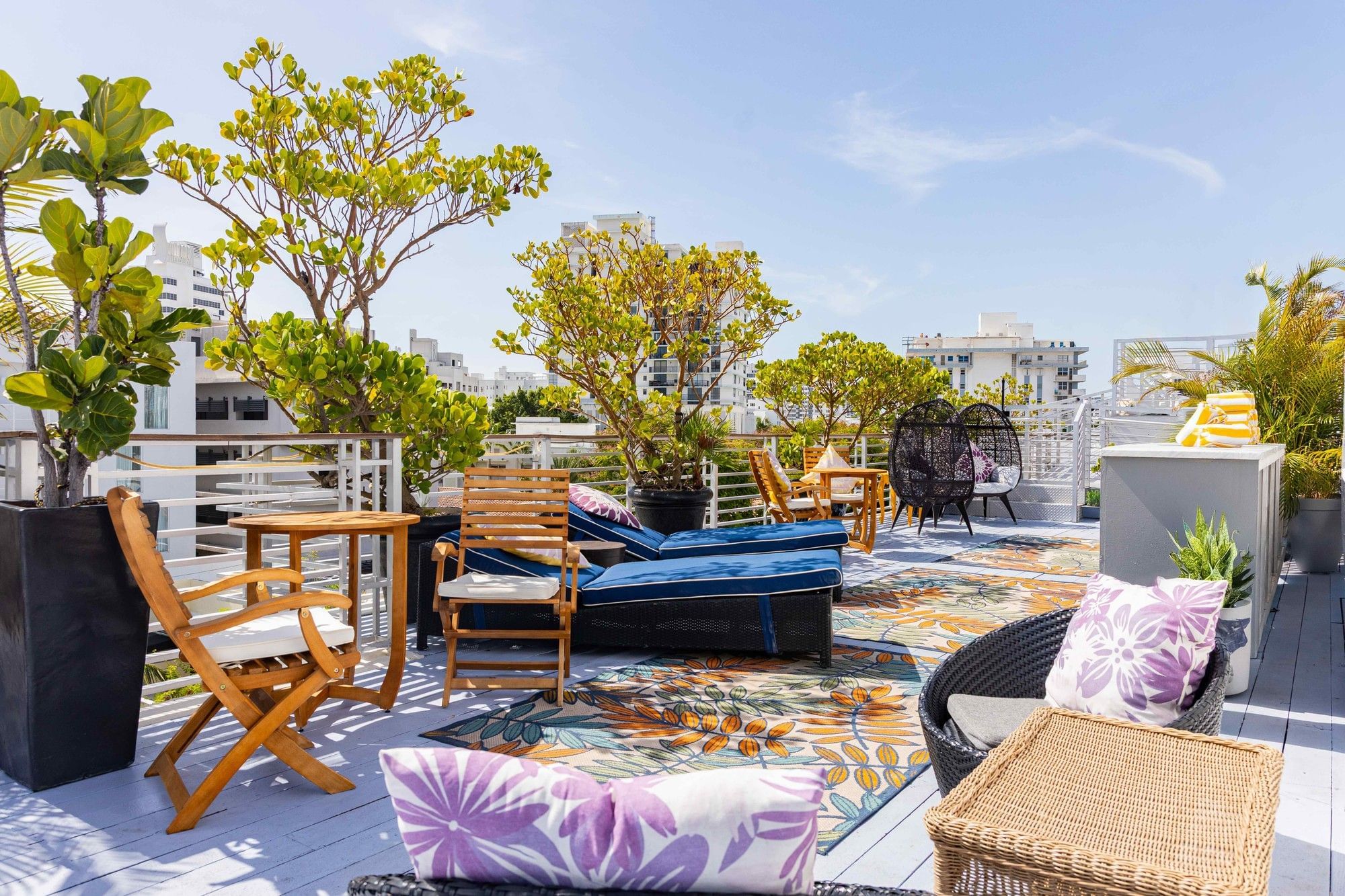 A rooftop lounge with outdoor furniture and plants