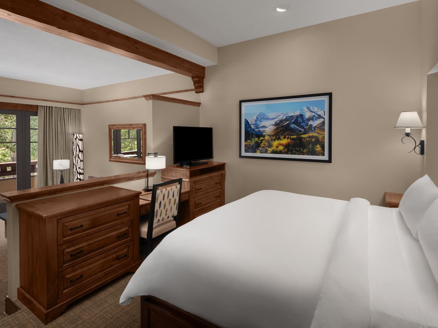 Executive Suite featuring cozy bed, wooden furnishings, TV & workspace at Hotel Park City Autograph Collection